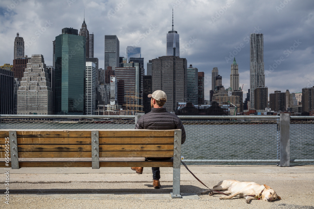 Fototapeta premium Mann mit Hund vor der Skyline Manhattan New York