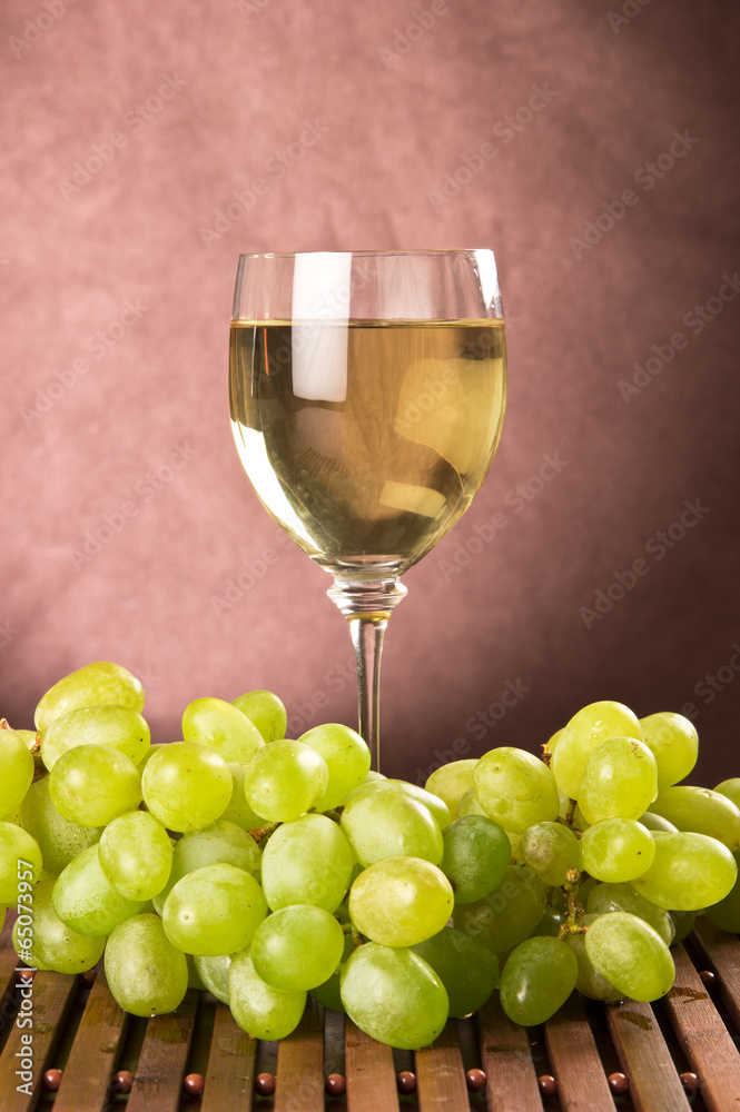 White wine in glass and green grapes