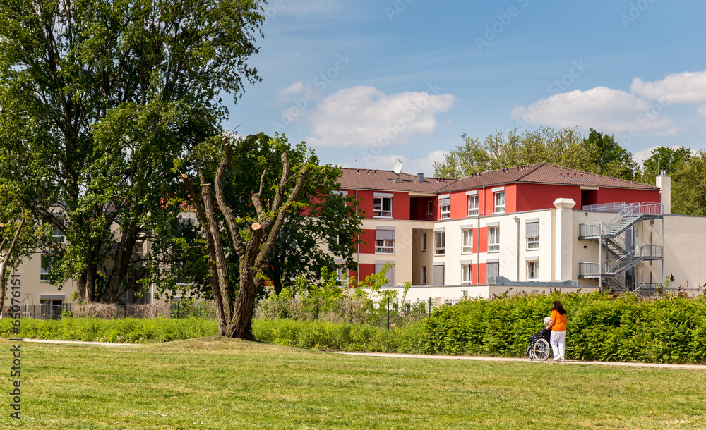 Carer with a senior citizen in a wheelchair on the way to the retirement home, Berlin, Germany