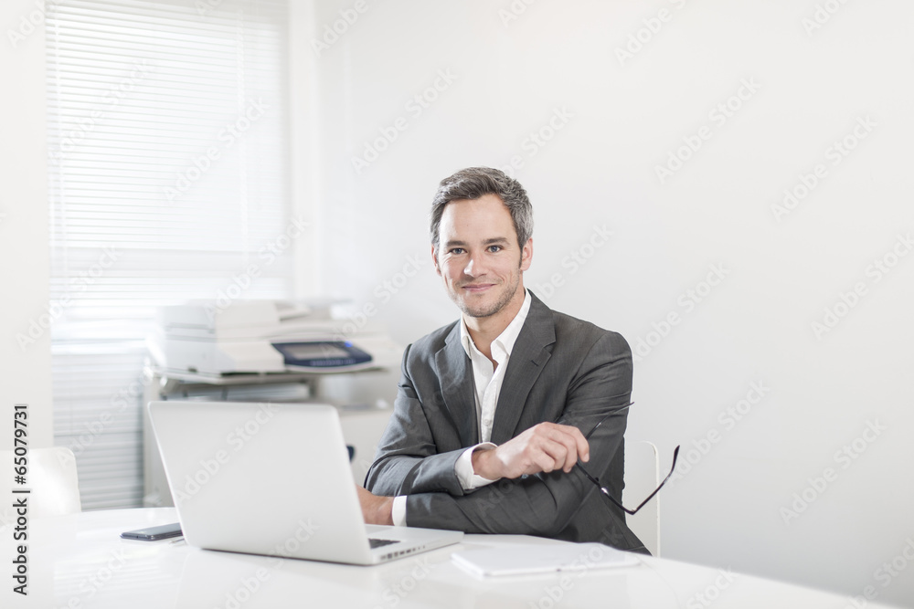 handsome businessman at office in front his laptop handsome businessman at office in front his laptop