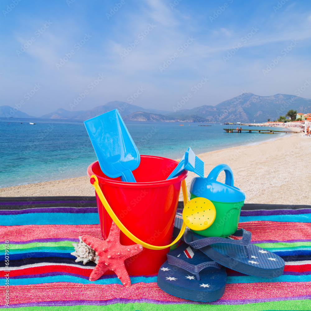 beach toys with flip flops and starfish on towel beach toys with flip flops and starfish on towel