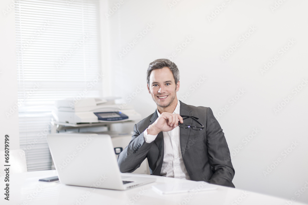 handsome businessman at office in front his laptop handsome businessman at office in front his laptop