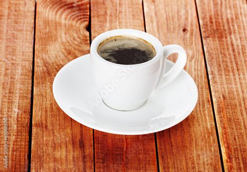 Coffee cup and saucer on a wooden background.