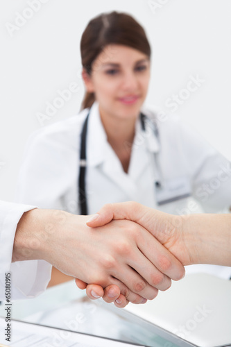 Doctors Shaking Hands At Desk