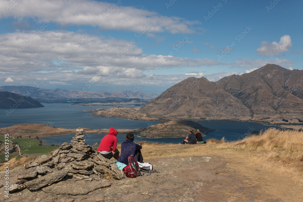 tourists resting above lake Wanaka, New Zealand