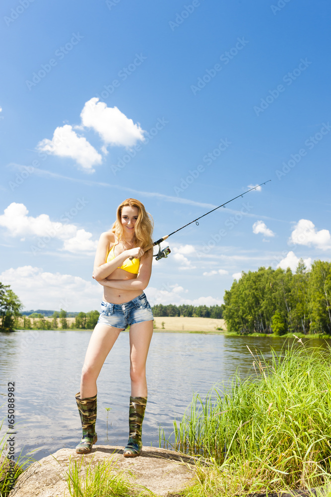 young woman fishing at pond in summer young woman fishing at pond in summer