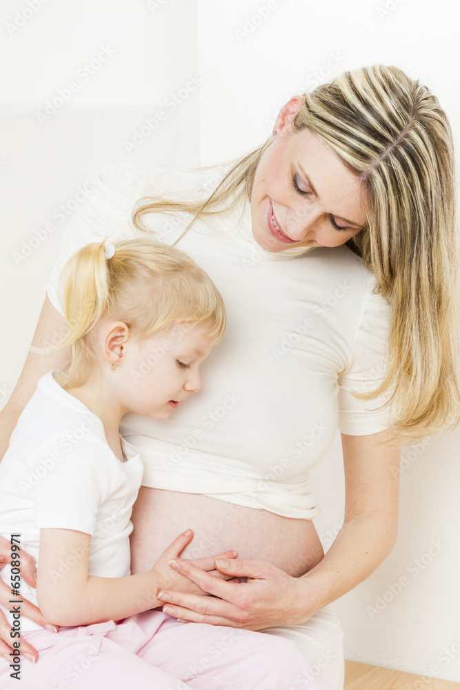 portrait of little girl with her pregnant mother portrait of little girl with her pregnant mother