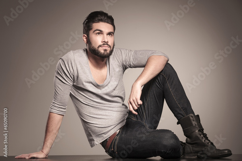 young casual man with beard looks up