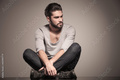 seated young man with beard looks away © Viorel Sima