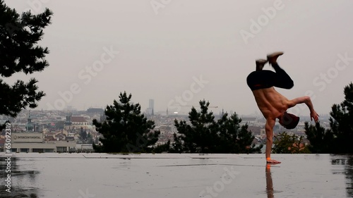 Breakdancer dancing breakdance in the rain in Prague photo