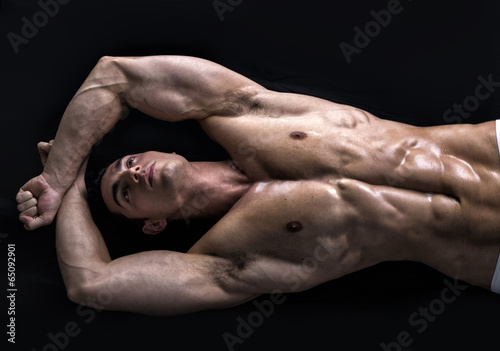 Foto Attractive young man on the floor with muscular ripped body