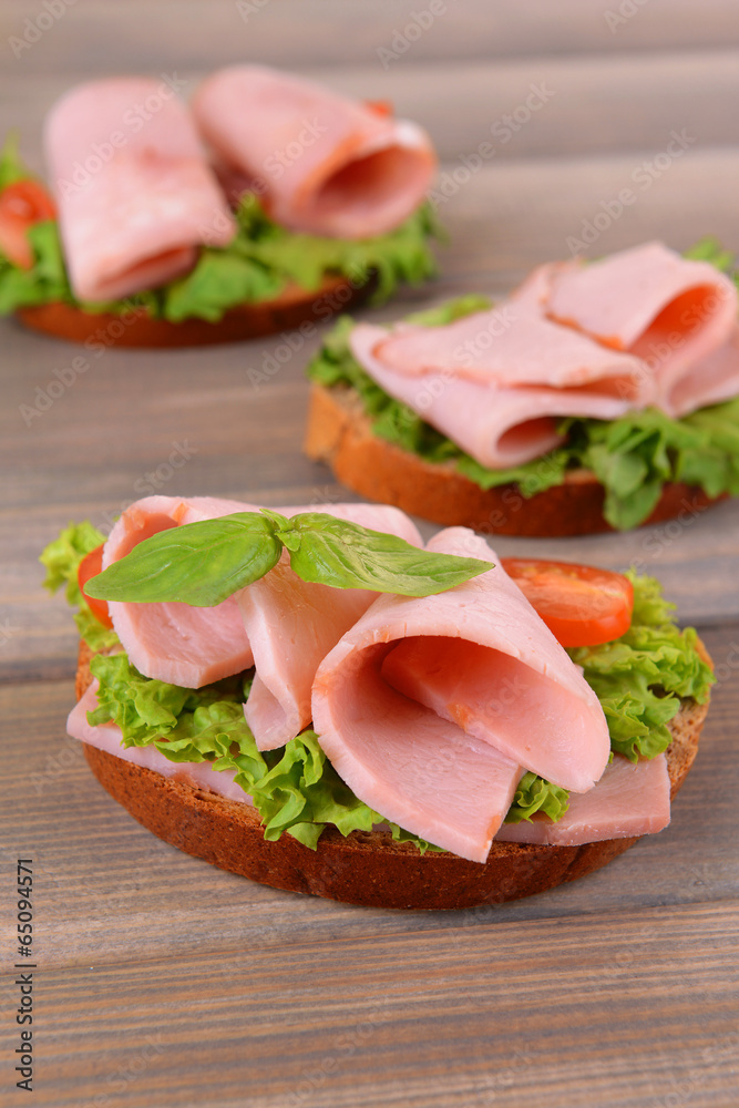 Delicious sandwiches with lettuce and ham on table close-up Delicious sandwiches with lettuce and ham on table close-up