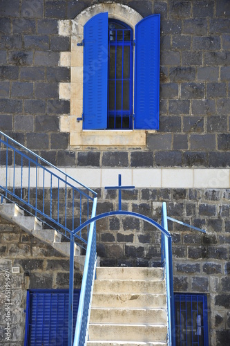 Entrance to the ancient house with blue windows, doors and handrails