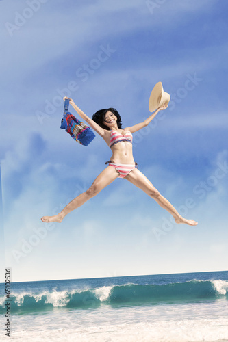 Excited girl jumping at a beautiful beach