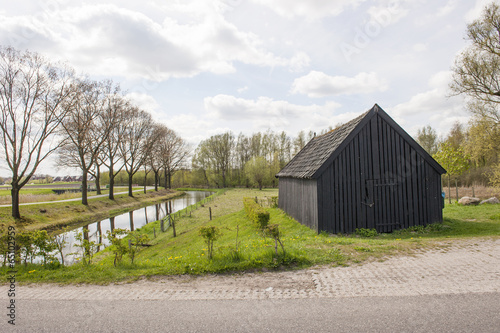 Black wooden shed near canal