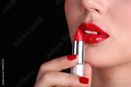 Girl with sexy red lips and pomade on dark background © Africa Studio