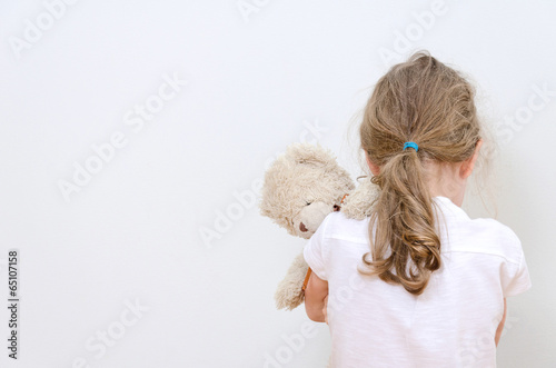 Little girl crying in the corner. Domestic violence concept.