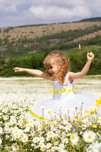 Cute child girl at camomile field