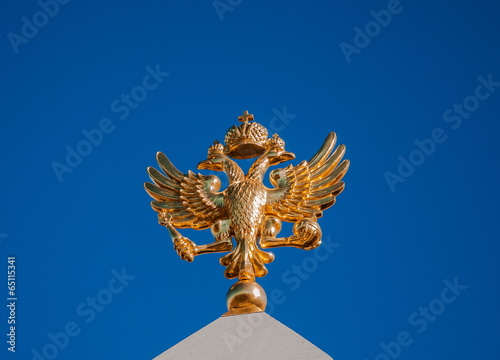 Golden two-headed eagle on a background of blue sky