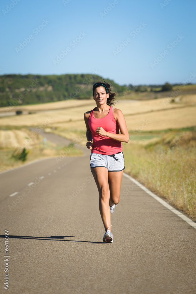 Female athlete running in country road