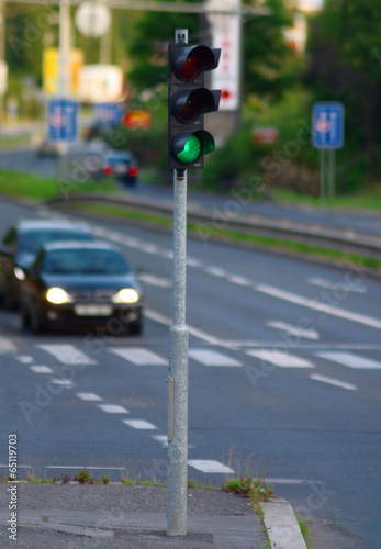 Green traffic lights and two cars on the road