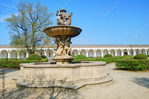 Historic fountain and long white colonnade in the background