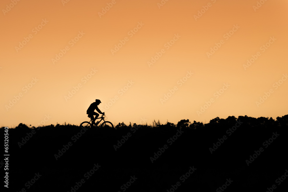 Silhouette of riding biker on sunset