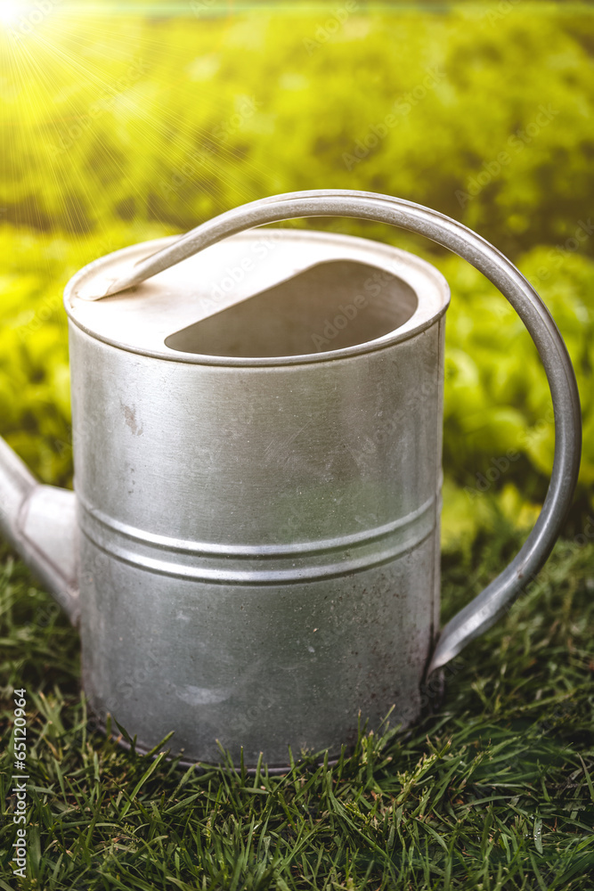 photo of watering can handle at sunny day at garden photo of watering can handle at sunny day at garden