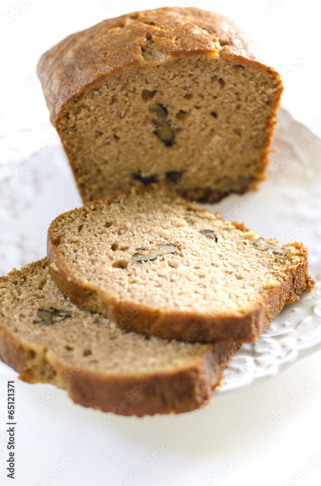 A loaf of fresh walnut bread on a white plate A loaf of fresh walnut bread on a white plate