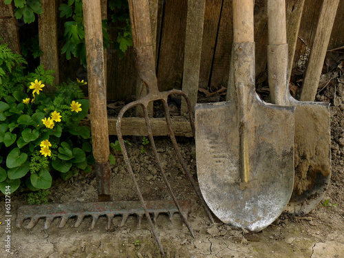 some garden tools near old wooden fence
