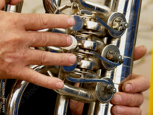 fragment of tuba with hands of musician photo