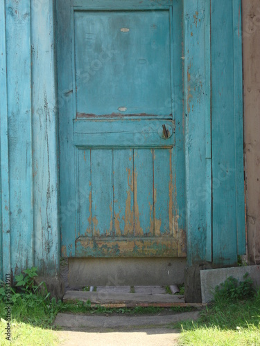 Винтаж голубая деревянная дверь в деревне, трава