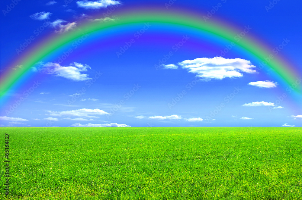 Green meadow, blue sky and a rainbow