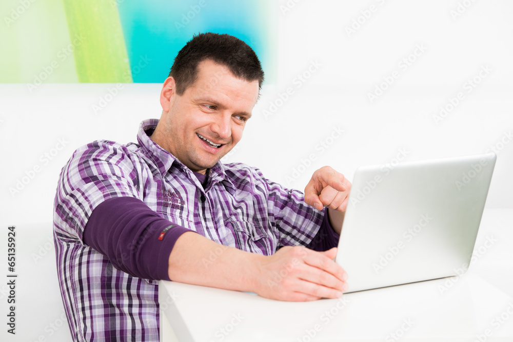 freundlicher mann sitzt begeistert am laptop freundlicher mann sitzt begeistert am laptop