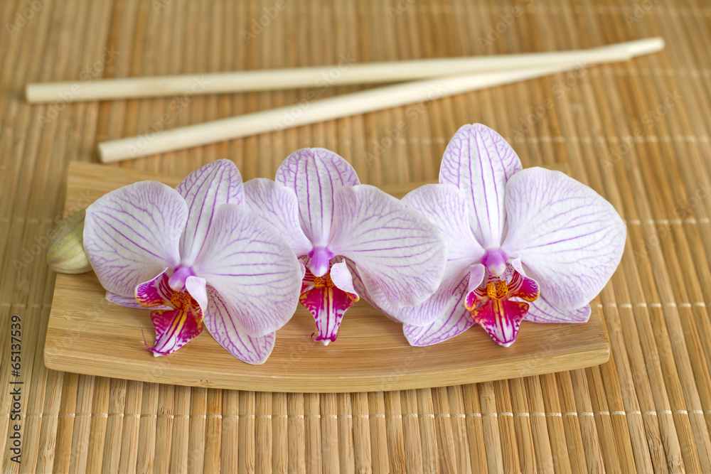 Orchids on bamboo mat abstract asian food unique concept Orchids on bamboo mat abstract asian food unique concept