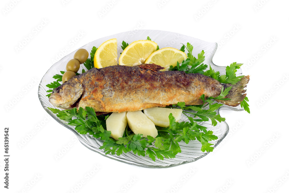 Roasted trout on the plate with parsley,lemon,potato and olives Roasted trout on the plate with parsley,lemon,potato and olives