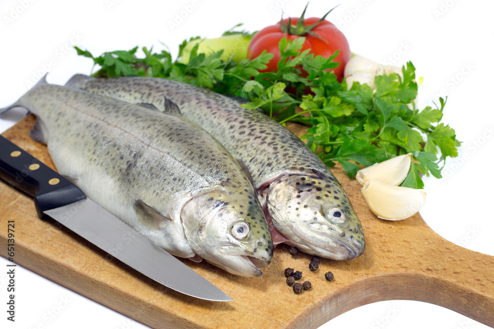 Fresh trout with parsley,garlic,tomato,pepper and knife Fresh trout with parsley,garlic,tomato,pepper and knife