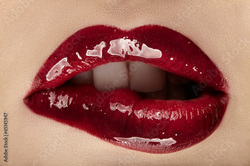 Beautiful female with red shiny lips close up