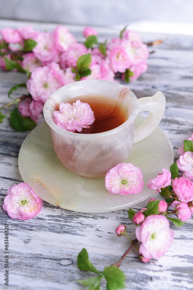 Beautiful fruit blossom with cup of tea on table close-up Beautiful fruit blossom with cup of tea on table close-up