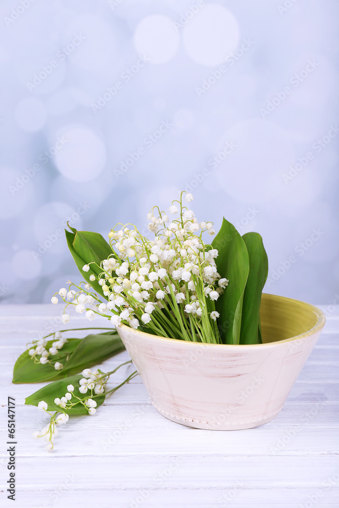 Beautiful lilies of the valley in vase on wooden table Beautiful lilies of the valley in vase on wooden table