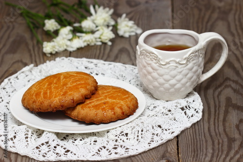 Baked cookies with tea and flowers.