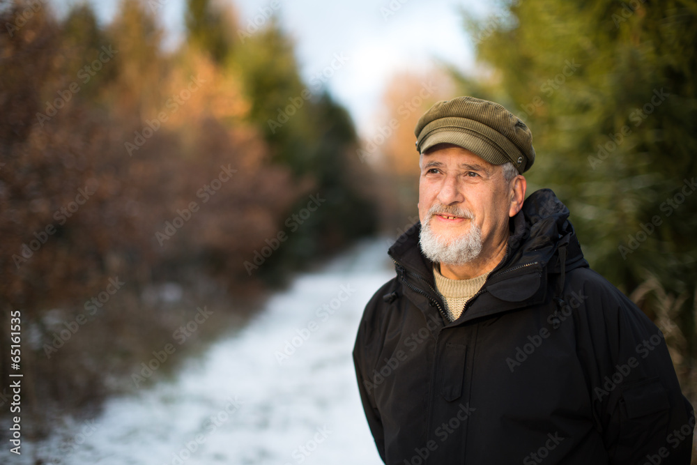 Portrait of a senior man, outdoor on a snowy forest path Portrait of a senior man, outdoor on a snowy forest path
