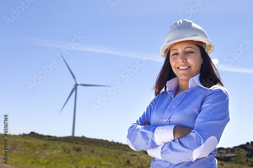 Beautiful engineer standing at wind farm photo