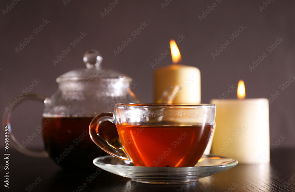 Composition with tea in glass teapot and candles Composition with tea in glass teapot and candles