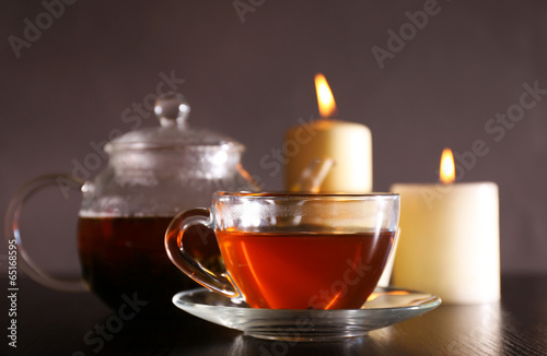 Composition with tea in glass teapot and candles