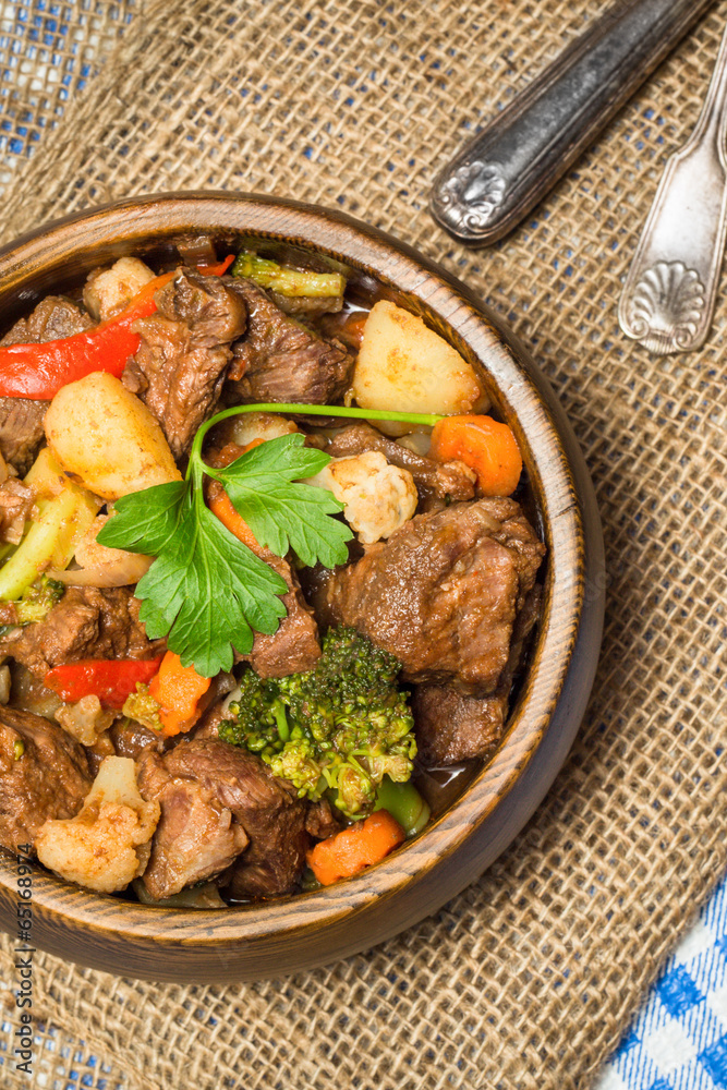 Hearty beef stew in wooden bowl Hearty beef stew in wooden bowl