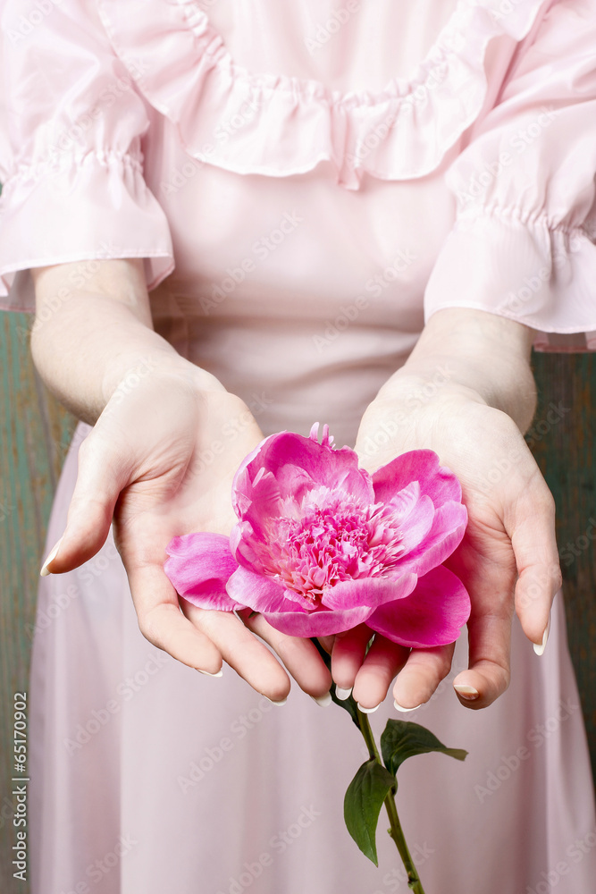 Woman in pink dress holding stunning pink peony