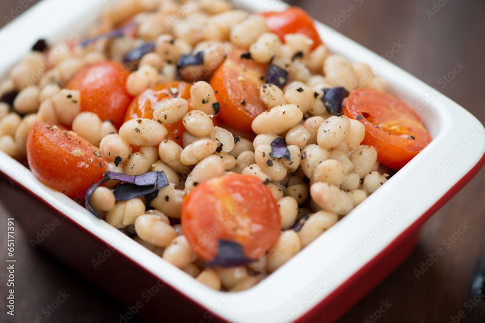 Glass bowl with roasted cherry tomatoes and white beans Glass bowl with roasted cherry tomatoes and white beans