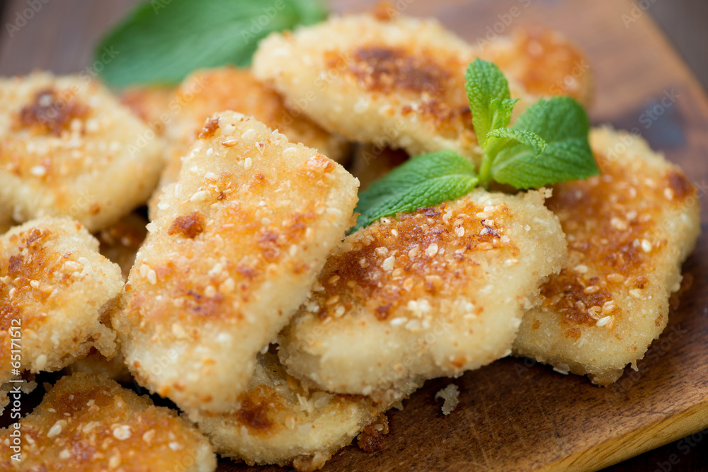 Sesame chicken nuggets with mint leaves, horizontal shot