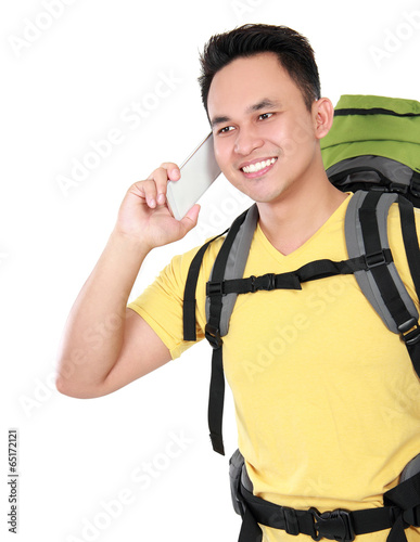 male hiker with backpack using mobile phone